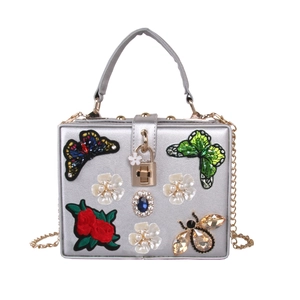 Silver evening clutch featuring butterfly embroidery, pearl flowers, and crystal accents