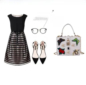 Flat lay set with embroidered butterfly handbag, striped sleeveless dress and black flats