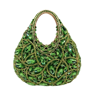 Close-up of emerald crystal evening clutch bag with intricate gold metal framing