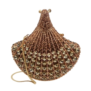 Close-up of fan-shaped golden clutch bag featuring intricate rows of sparkling rhinestones