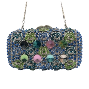 Macro detail of luxury evening clutch bag with blue-green rhinestones and multi-color gems