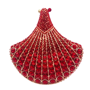 Macro view of fan-shaped clutch bag featuring red rhinestones and peacock metal clasp