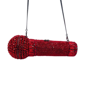 Detailed view of luxury microphone shaped clutch bag with red rhinestones and chain