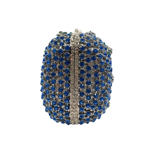 Macro shot of silver frame detail with blue and white crystals on oval evening clutch bag