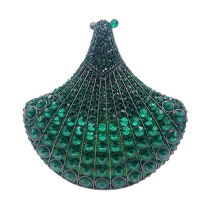 Detailed view of luxury fan-shaped clutch bag with emerald green crystal embellishments