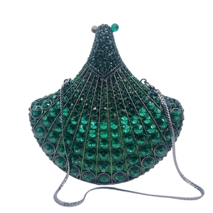 Detail of emerald green fan-shaped clutch bag with sparkling crystals and silver chain