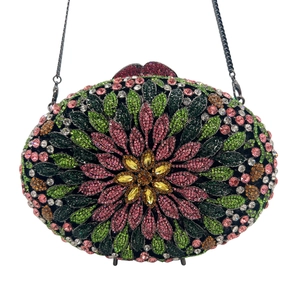 Macro view of crystal encrusted floral pattern on luxury evening clutch bag with chain