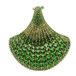 Close-up of fan-shaped clutch bag with emerald green rhinestones and golden metal frame