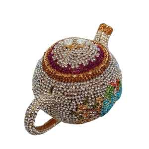 Detailed macro view of crystal teapot clutch bag with intricate bird floral patterns