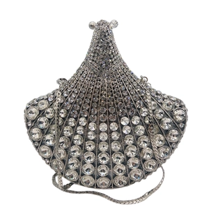 Macro shot of shell-shaped clutch bag with silver rhinestones and metal chain strap