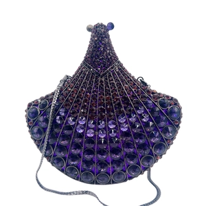 Detailed macro view of sparkling purple rhinestone pattern on the luxury fan-shaped clutch