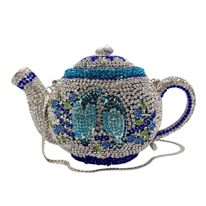 Detailed view of teapot evening bag with floral rhinestone embroidery and silver chain