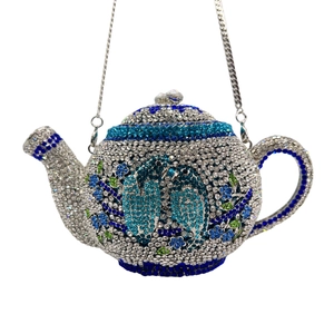 Detail of crystal-encrusted teapot clutch bag with floral rhinestone patterns and chain