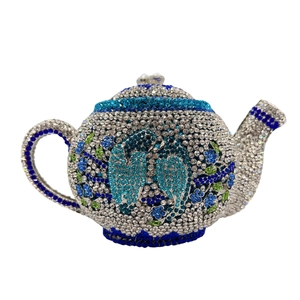 Macro detail of luxury teapot clutch bag featuring intricate blue crystal bird pattern