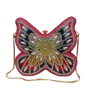Detailed macro of a butterfly clutch bag with colorful rhinestones and gold chain