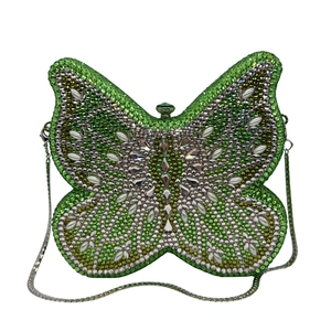 Detailed view of butterfly evening clutch with green and white rhinestone wing pattern