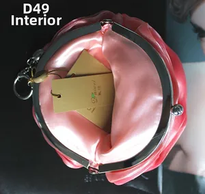 Vue détaillée de l'intérieur d'un sac de soirée en satin rose avec fermoir en métal argenté