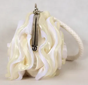 Détail du sac de soirée en soie plissée avec motif floral et poignée tressée
