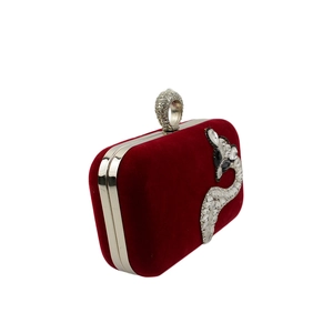 Close-up of luxury burgundy velvet evening clutch with crystal fox and ring clasp