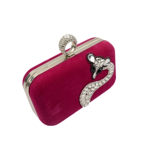 Detail of fuchsia velvet evening clutch with silver rhinestone fox clasp and crystal snake