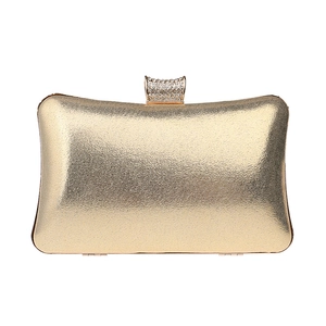 Macro shot of gold metallic clutch bag featuring a luxurious sparkling rhinestone clasp