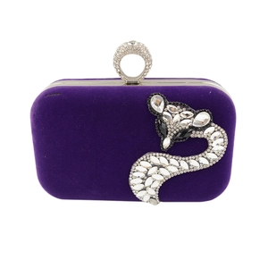 Detail of purple velvet clutch featuring a rhinestone fox and crystal ring clasp