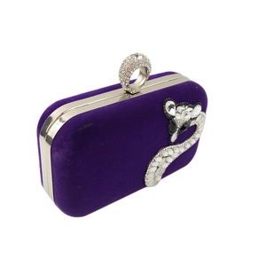 Detail of purple velvet evening clutch featuring silver snake rhinestone design and ring clasp
