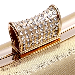 Macro shot of sparkling gold clutch buckle adorned with shimmering crystals and rhinestones