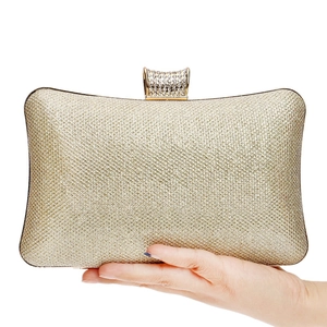 Detail of champagne gold glitter evening clutch bag with sparkling rhinestone top clasp