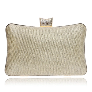 Detail of the elegant gold evening clutch bag with sparkling texture and crystal clasp