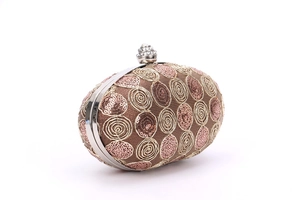 Macro view of rose gold oval evening clutch with gold spiral embroidery and sequin details
