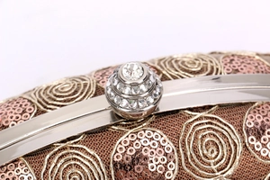 Macro shot of rose gold evening clutch featuring sequin beadwork and crystal-encrusted clasp