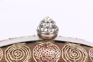 Macro view of rose gold sequins, spiral embroidery and crystal inlaid pagoda clasp