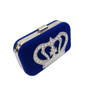 Detail of royal blue velvet clutch with crystal crown and gold metal frame closure