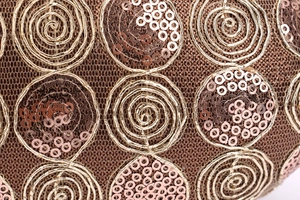 Macro shot of gold spiral embroidery and bronze sequins on premium lace evening clutch