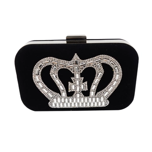 Detail of black velvet clutch bag featuring a sparkling rhinestone crown and silver clasp