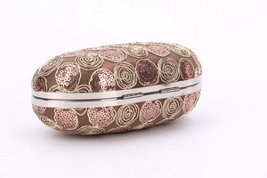 Detail of oval evening clutch with pink sequins and gold embroidery on brown mesh