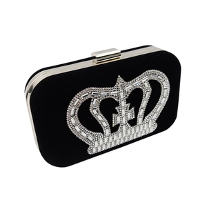 Detail of elegant black velvet evening clutch with sparkling silver rhinestone crown