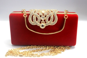 Vue macro de la pochette de soirée en velours rouge avec boucle couronne en strass