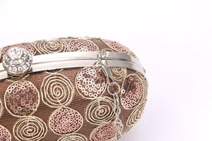 Detail of sequins spiral texture and silver spherical rhinestone clasp on bridal clutch