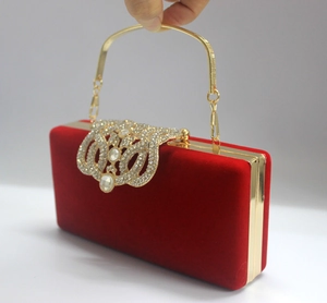Détail de la pochette de soirée en velours rouge avec poignée dorée et décor strass