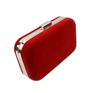 Detail of red velvet clutch bag with silver metal frame and rectangular push clasp