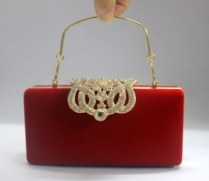 Détail du sac de soirée en velours rouge avec anse dorée et boucle strass rétro