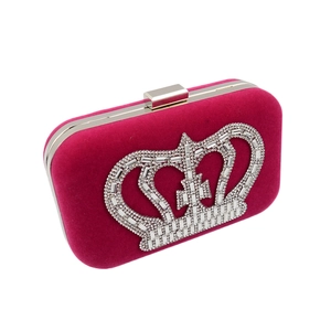 Detail view of fuchsia velvet clutch bag with large crystal crown embellishment