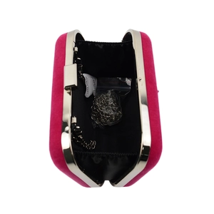 Detail of open fuchsia velvet evening bag with silver chain strap and metal clasp