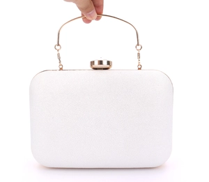 Close-up of white leather evening clutch with gold ring handle and crystal clasp detail