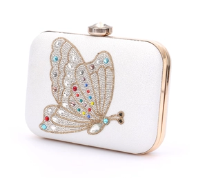 Detail of white evening clutch with colorful crystal butterfly and gold metal frame