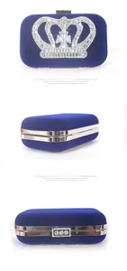 Detail of navy blue velvet evening clutch with crown rhinestone decoration and metal frame