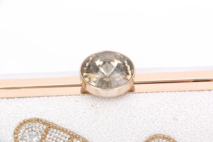 Close-up of gold metal frame and oversized crystal clasp on luxury evening clutch bag