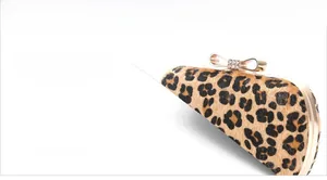 Detail of leopard print evening bag with golden bow clasp and shimmering crystal accents